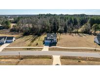 Spacious two-story home with a two-car garage and expansive front yard, near a wooded area at 105 Langdon Chase Way, Selma, NC 27576