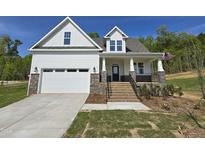 Charming new construction home featuring white siding, stone accents, and an inviting front porch at 1116 Prominence Dr., Homesite 31, Durham, NC 27712