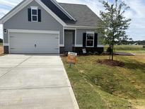 Charming single-Gathering home boasts a well-manicured lawn and attached two-car garage at 14 E American Marigold Dr # 65, Benson, NC 27504