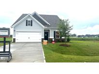Charming single-Gathering home featuring a well-manicured lawn, attached garage, and neutral exterior at 14 E American Marigold Dr # 65, Benson, NC 27504