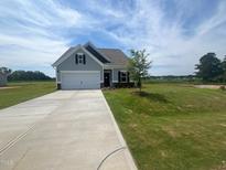 Charming single-story home with a manicured lawn, long driveway, and a welcoming entrance at 14 E American Marigold Dr # 65, Benson, NC 27504