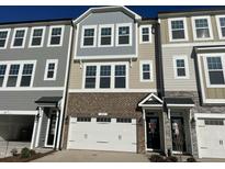 Modern 3-story townhome with attached garage and brick accents at 2107 Lambert Rd # 64, Cary, NC 27519