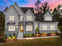 Stunning two-story home with gray and white siding, landscaping, and a metal roof at 2404 Toll Mill Ct, Raleigh, NC 27606