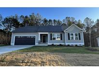 One-story house with gray siding, black shutters, and a two-car garage at 257 Magnolia Run Way, Benson, NC 27504