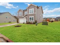 Charming two-story home with manicured lawn and attached two-car garage at 104 Davinhall Dr, Fuquay Varina, NC 27526