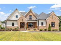 Brick and siding two-story home with a covered porch and manicured lawn at 1505 Montvale Grant Way, Cary, NC 27519