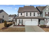 Two-story townhome with gray siding, white garage door, and landscaping at 3200 Retama, New Hill, NC 27562