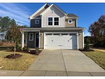 Two-story house with beige siding, white trim, and a two-car garage at 36 Railcar Way, Clayton, NC 27520