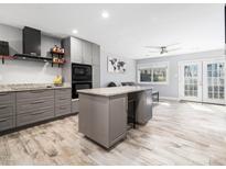 Modern kitchen with gray cabinets, granite counters, stainless steel appliances, and a central island at 4236 Lake Ridge Dr, Raleigh, NC 27604