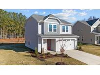Charming two-story home featuring a gray exterior, landscaped front yard, and an attached two-car garage at 48 Railcar Way, Clayton, NC 27520