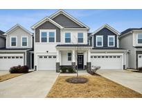 Two-story townhome with gray and white siding, two-car garage, and landscaping at 747 Creekway Dr, Fuquay Varina, NC 27526