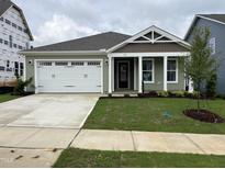 Newly constructed home with a two-car garage and well-manicured lawn at 76 Brooklynn Trl, Angier, NC 27501