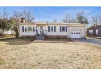 Charming ranch home with a spacious yard, attached garage, and welcoming front porch at 85 W Cornwallis St, Pittsboro, NC 27312