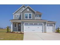 Two-story house with gray siding, white trim, and a three-car garage at 86 Barn Door Dr, Lillington, NC 27546