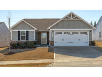 Gray exterior with white garage door, landscaping, and a stone accent at 8798 Kenridge Ln, Fuquay Varina, NC 27526