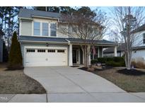 Charming two-story home with a two-car garage and landscaped front yard with tasteful plantings at 104 Warm Wood Ln, Apex, NC 27539