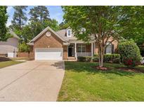 Charming brick home with a well-manicured lawn and a two-car garage in a leafy neighborhood at 107 Myers Farm Ct, Cary, NC 27519