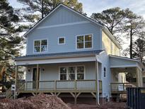 Two-story house with light blue siding, front porch, and attached garage at 1203 Chaney Rd, Raleigh, NC 27606
