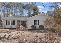 White single story house with black shutters, wood steps, and landscaping at 1437 Huntly Ct, Cary, NC 27511
