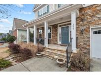 Inviting front porch features stone accents, stately columns, and a charming blue front door at 200 Callandale Ln, Durham, NC 27703