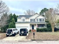 Charming two-story home with a manicured lawn and attached two car garage on a tree-lined street at 2421 Barton Oaks Dr, Raleigh, NC 27614
