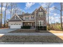 Two-story home with stone accents and a three-car garage at 2901 Water Tower Ln, Apex, NC 27502