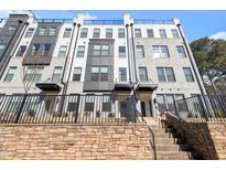 Three-story townhome with modern gray and white exterior, black railings, and stone accents at 437 Wait Ave # 100, Wake Forest, NC 27587
