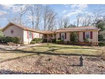 Ranch style home with brick and siding exterior, landscaped lawn, and mature trees at 5416 Fairoaks Rd, Durham, NC 27712