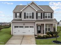Charming two-story home featuring a well-maintained lawn and a two-car garage at 6 S Stonehaven Way, Clayton, NC 27527