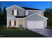 Charming two-story home with blue siding, a two-car garage, and a well-manicured lawn, creating a welcoming curb appeal at 1725 Pie Filling Dr, Haw River, NC 27258