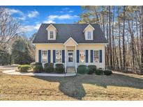 Charming yellow house with blue shutters and well-maintained lawn at 215 W Chestnut Ave, Wake Forest, NC 27587