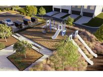 Aerial view of a community playground featuring slides, climbing structures, and benches within a landscaped setting at 277 Chesapeake Commons St # 94, Garner, NC 27529