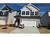 Charming two-story home with gray siding, black shutters, a two-car garage, and a well-manicured front lawn at 34 Fairwinds Dr, Lillington, NC 27546