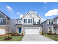 Charming two-story home features a modern facade, two-car garage, and well-manicured lawn at 34 Fairwinds Dr, Lillington, NC 27546