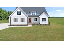 Charming new construction farmhouse with a bright red front door, black shutters, and a well-manicured lawn at 5377 River Buck Rd, Spring Hope, NC 27882