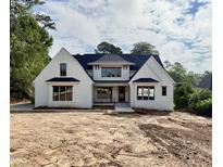 Stunning new construction, white brick home featuring black trim and dark roof at 5820 Shawood Dr, Raleigh, NC 27609