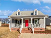 Gray house with red door, brick steps, and a front porch at 813 Kimpton Ct, Fuquay Varina, NC 27526