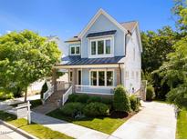Charming two-story home with a welcoming front porch and professionally landscaped front yard at 1000 Norris St, Raleigh, NC 27604