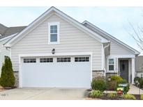 Charming home featuring a two-car garage, stone accents, neutral siding, and well-manicured landscaping at 125 Canary Ct. Ct, Raleigh, NC 27610