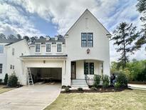 Striking two-story white brick home with a finished front yard and an attached two-car garage at 1725 Burnette Garden Path, Raleigh, NC 27612