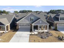 Attractive craftsman style home with gray siding, stone accents, and a two-car garage at 301 Crayton Oak Dr, Cary, NC 27519