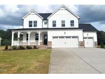 Charming two-story home featuring a welcoming front porch and a spacious three-car garage at 53 Priming Way, Angier, NC 27501
