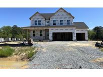 New two-story home showcasing a modern architectural style in the early stages of construction with a visible gravel driveway at 53 Priming Way, Angier, NC 27501