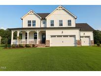 Charming two-story home featuring a welcoming front porch and an attached two-car garage at 53 Priming Way, Angier, NC 27501