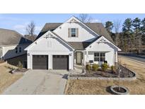 Two-story white house with dark brown garage doors and landscaping at 68 Sugar Maple Way, Youngsville, NC 27596