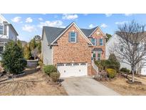 Charming two-story brick home featuring an attached two-car garage and well-manicured landscaping at 912 Jewel Stone Ln, Morrisville, NC 27560