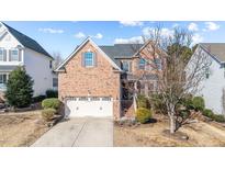 Charming two-story brick home with attached garage, beautiful landscaping, and a well-maintained yard at 912 Jewel Stone Ln, Morrisville, NC 27560