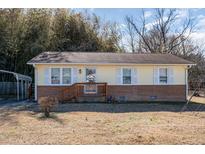 Charming, single-story home with light yellow siding, a brick foundation and covered front porch at 107 Cedar Ct, Oxford, NC 27565