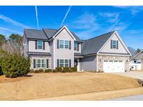 Two-story house with gray siding, stone accents, and a three-car garage at 139 Red Angus Dr, Smithfield, NC 27577
