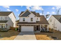 Two-story home with white siding, gray roof, and a two-car garage at 1416 Weavers Trace Dr, Zebulon, NC 27597